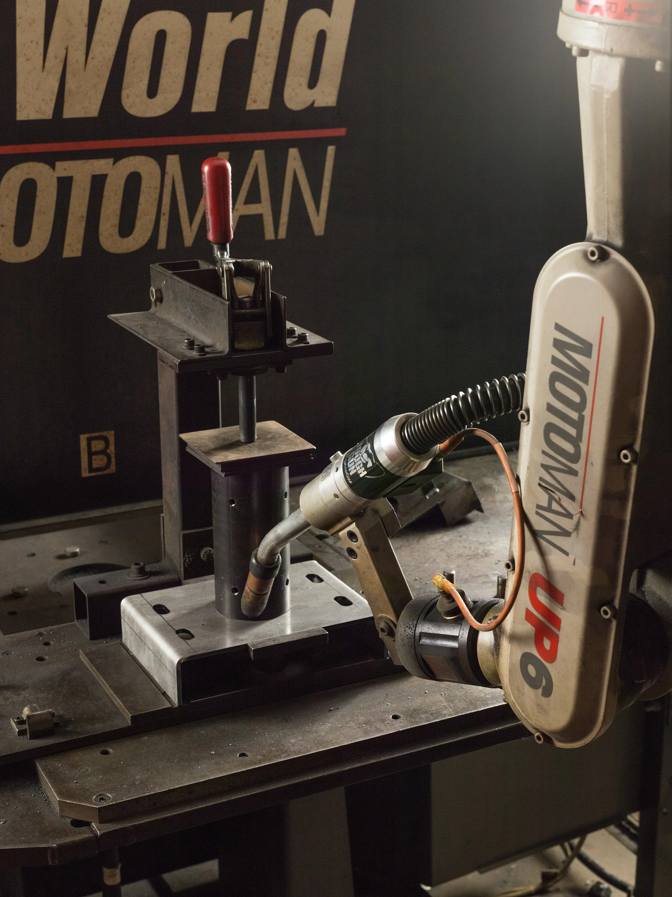 Robot welder positioned to weld tube and bracket